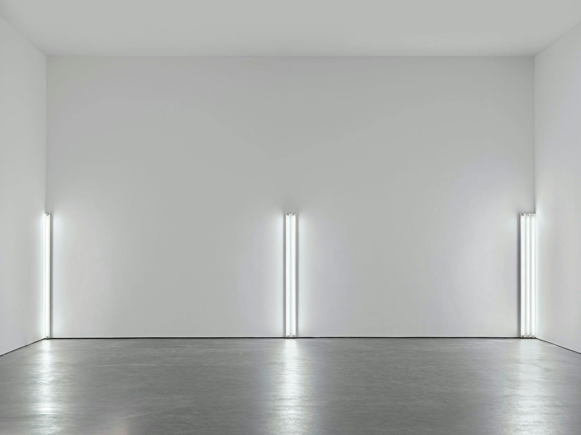 An artwork by Dan Flavin, titled the nominal three (to William of Ockham), dated 1963. copyright 2024 Stephen Flavin / Artists Rights Society (ARS), New York.